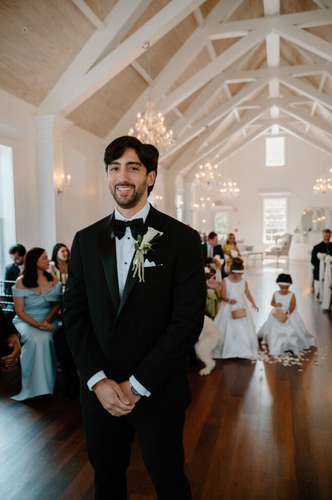 Groom reacting as his bride walks down the aisle during their wedding ceremony